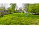 Expansive backyard with lush green grass and play equipment, offering plenty of space for outdoor activities and recreation at 440 E 82Nd St, Indianapolis, IN 46240