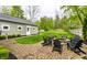 Beautiful backyard with a stone firepit, chair seating and a lush lawn surrounded by a privacy fence and mature trees at 440 E 82Nd St, Indianapolis, IN 46240