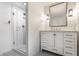 Clean bathroom featuring a glass shower, a white marble topped vanity with drawers and cabinets, and modern lighting at 440 E 82Nd St, Indianapolis, IN 46240