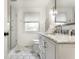 Bright bathroom featuring a glass-enclosed shower, white vanity, marble countertop, and unique patterned tile flooring at 440 E 82Nd St, Indianapolis, IN 46240
