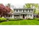Charming two-story home with a stone facade, manicured lawn, and mature trees at 440 E 82Nd St, Indianapolis, IN 46240
