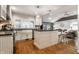 Bright kitchen features wood floors, island, white cabinets, and stainless appliances at 440 E 82Nd St, Indianapolis, IN 46240