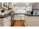 Bright kitchen features wood floors, shaker cabinets, and modern farmhouse sink at 440 E 82Nd St, Indianapolis, IN 46240