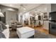 Open concept with a white ottoman, accent chair, and hardwood floors at 440 E 82Nd St, Indianapolis, IN 46240