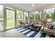 Bright sunroom with abundant natural light, comfortable seating, and views of the green backyard and a blue stripe rug at 440 E 82Nd St, Indianapolis, IN 46240