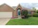 Charming brick home featuring a well-maintained lawn and colorful landscaping with an attached garage at 4652 Kensington N Way, Plainfield, IN 46168