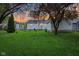 Evening backyard showcasing a green lawn and cozy seating around the home at 473 N 17Th St, Noblesville, IN 46060