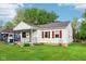 Quaint home with charming details like red shutters, covered porch, and lush lawn, creating a welcoming facade at 473 N 17Th St, Noblesville, IN 46060