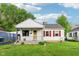 Charming home featuring white siding, red shutters, a cozy front porch, and well-maintained landscaping at 473 N 17Th St, Noblesville, IN 46060