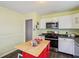 Kitchen with stainless steel appliances, white cabinets, and island with red base at 473 N 17Th St, Noblesville, IN 46060