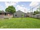 Large, well-maintained backyard with green grass, partial privacy fence and a young tree at 4902 Kingsley Dr, Indianapolis, IN 46205