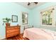 Cozy bedroom featuring hardwood floors, two windows, dresser, and vintage-style furniture at 4917 N Park Ave, Indianapolis, IN 46205
