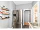 Well-lit kitchen features a stainless steel refrigerator and floating shelves for extra storage at 4917 N Park Ave, Indianapolis, IN 46205