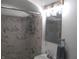 Bathroom with shower and marble tile surround, framed mirror, modern faucet, and towel rack at 4927 Mathews Ave, Indianapolis, IN 46227