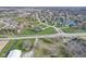High-angle view of a neighborhood with homes encircling a pond, interspersed with blooming trees, creating a peaceful setting at 4940 Sundance Trl, Indianapolis, IN 46239