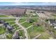 Expansive aerial view of a suburban neighborhood with lush green lawns and varied home styles amid a scenic landscape at 4940 Sundance Trl, Indianapolis, IN 46239