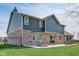 Two-story home featuring a brick-look foundation and backyard patio at 4940 Sundance Trl, Indianapolis, IN 46239