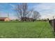 Expansive backyard with mature trees, lush green lawn, and partial view of the home's exterior at 4940 Sundance Trl, Indianapolis, IN 46239