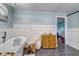 Bright bathroom with a standalone tub, stylish cabinet, and light blue paneled walls at 4940 Sundance Trl, Indianapolis, IN 46239
