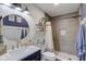 Updated bathroom featuring a tiled shower, shiplap walls, and a round mirror at 4940 Sundance Trl, Indianapolis, IN 46239