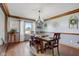 Elegant dining room with wood-trimmed walls and traditional wood table with seating for six at 4940 Sundance Trl, Indianapolis, IN 46239