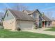 A charming home featuring a two-car garage, brick accents, and fresh green lawn on a sunny day at 4940 Sundance Trl, Indianapolis, IN 46239