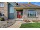 A charming home featuring a brick exterior and a welcoming red front door with sidelight windows at 4940 Sundance Trl, Indianapolis, IN 46239