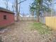 Spacious backyard with grass and fallen leaves, wooden fence, and shed at 5080 Norwaldo Ave, Indianapolis, IN 46205