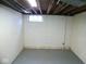 Clean basement with painted concrete block walls, small window, and exposed ceiling at 5080 Norwaldo Ave, Indianapolis, IN 46205