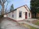 Charming single-story home with red door, concrete steps and sidewalk, and a detached garage at 5080 Norwaldo Ave, Indianapolis, IN 46205