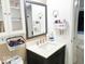 This bathroom features a dark vanity, a mirror, and white cabinets at 5411 Cliff Ridge Dr, Indianapolis, IN 46217