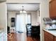 A well-lit dining area with hardwood floors, a chandelier, and neutral curtains for an elegant and comfortable atmosphere at 5411 Cliff Ridge Dr, Indianapolis, IN 46217