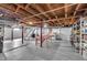 Unfinished basement with exposed wood ceiling beams, painted walls, and concrete flooring at 5504 Indianola Ave, Indianapolis, IN 46220