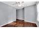 A well-lit bedroom featuring hardwood floors, a ceiling fan, and a large window at 5504 Indianola Ave, Indianapolis, IN 46220