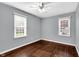 Bright bedroom with hardwood floors, ceiling fan, and two large windows at 5504 Indianola Ave, Indianapolis, IN 46220