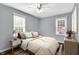 Well-lit bedroom with hardwood floors, a large bed, and two bright windows at 5504 Indianola Ave, Indianapolis, IN 46220
