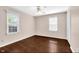 Bright bedroom with hardwood floors, ceiling fan, and two large windows at 5504 Indianola Ave, Indianapolis, IN 46220
