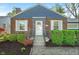 Close-up of a classic brick home with a tidy front yard and a welcoming white front door at 5504 Indianola Ave, Indianapolis, IN 46220