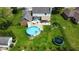 Aerial view of a backyard with a pool, deck, patio, and trampoline in the fenced yard at 562 Covered Bridge Rd, Greenwood, IN 46142