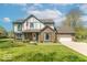 Charming two-story home with a brick facade, manicured lawn, and an American flag at 562 Covered Bridge Rd, Greenwood, IN 46142
