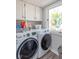 Convenient laundry room with modern washer and dryer, ample storage, and a window overlooking the backyard at 562 Covered Bridge Rd, Greenwood, IN 46142