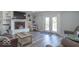 Cozy living room with a fireplace, neutral furniture, wood floors, and double doors to the exterior at 562 Covered Bridge Rd, Greenwood, IN 46142