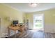 Sunny home office featuring light yellow walls, wainscotting, wood-look flooring and large window at 562 Covered Bridge Rd, Greenwood, IN 46142