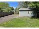 View of a one-car garage with blue siding, a gravel driveway, and well-maintained yard at 5938 Haverford Ave, Indianapolis, IN 46220