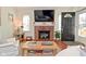 Living room with brick fireplace, TV, arched front door, and hardwood floors at 5938 Haverford Ave, Indianapolis, IN 46220