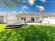 Well-maintained backyard with a patio, wooden deck, and lush green lawn at 6146 Franklin Villas Way, Indianapolis, IN 46237