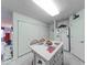 Well-lit kitchen boasts tile flooring, white cabinets and appliances, with an island in the center at 6146 Franklin Villas Way, Indianapolis, IN 46237