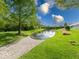 Scenic backyard pond with lush greenery and a rock lined path at 6146 Franklin Villas Way, Indianapolis, IN 46237