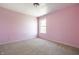 This bedroom offers a neutral carpet, a window for natural light, and a soft pink color at 6472 Creekshore Ln, Indianapolis, IN 46268