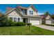 Charming two-story home with a well-manicured lawn and an attached two-car garage in a suburban neighborhood at 6472 Creekshore Ln, Indianapolis, IN 46268